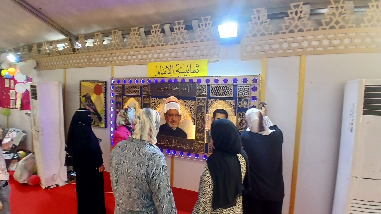 «ثمانينية الإمام».. جدارية الأزهر بعد اكتمالها تتحول إلى أيقونة بصرية تجذب زوار معرض مكتبة الإسكندرية للكتاب 6 «ثمانينية الإمام».. جدارية الأزهر بعد اكتمالها تتحول إلى أيقونة بصرية تجذب زوار معرض مكتبة الإسكندرية للكتاب
